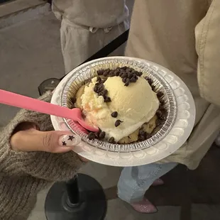 a person holding a plate of ice cream