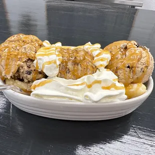 a banana split with caramel sauce and whipped cream