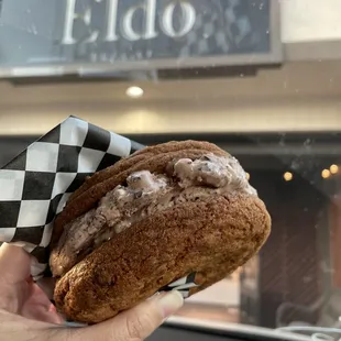 a person holding a sandwich in their hand