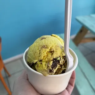 a hand holding a bowl of ice cream
