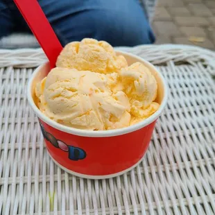 a cup of ice cream on a wicker table