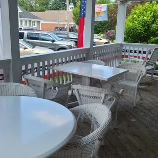 a porch with tables and chairs
