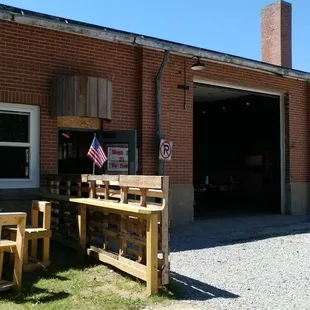a table and benches in front of a garage