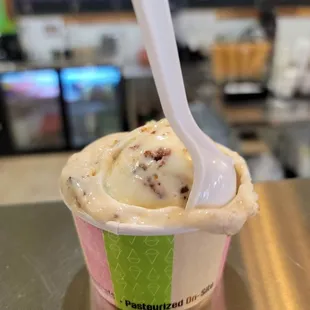 a cup of ice cream with a spoon sticking out of it