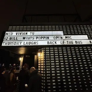 people standing outside of a theater