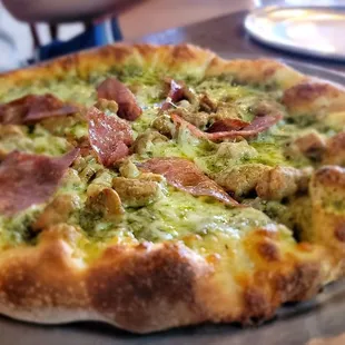Custom personal pizza: salami and sausage with pesto sauce