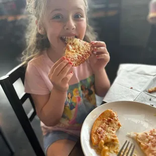 My daughter enjoying the kids cheese pizza