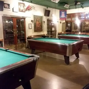 a row of pool tables in a bar