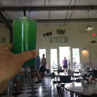 a person holding a green drink