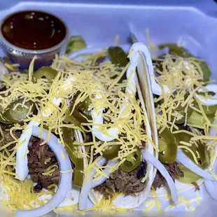 a plate of tacos with meat and cheese