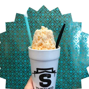 a hand holding a cup of ice cream