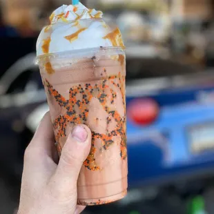 a hand holding a cup of iced coffee