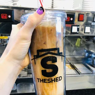 a hand holding a cup of iced coffee