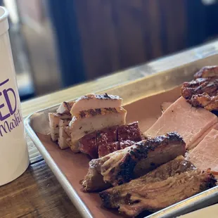 a tray of meat and a drink