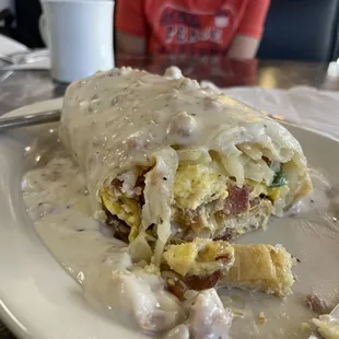 Breakfast Burrito, not on menu:eggs, hash browns, bacon, cheese, jalapeños and sausage gravy on top!!! Soooo good!