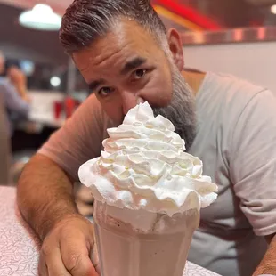 a man eating a milkshake