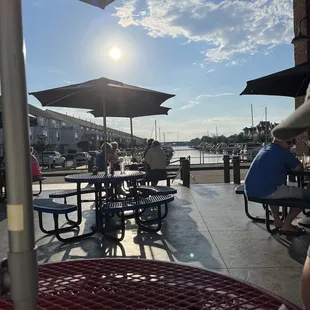 people sitting at tables with umbrellas