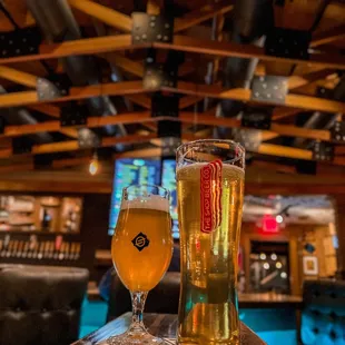 two glasses of beer on a bar