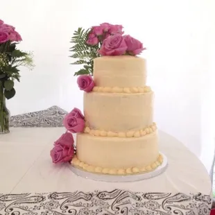 a wedding cake with pink roses