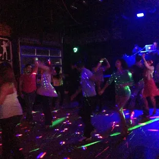 a group of people dancing on a dance floor