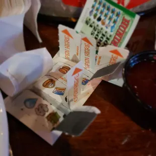 a fork, spoon, napkins, and a packet of ketchup sitting on a table
