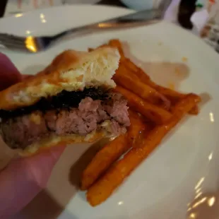 a person holding a sandwich and french fries