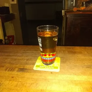 a glass of beer on a wooden table