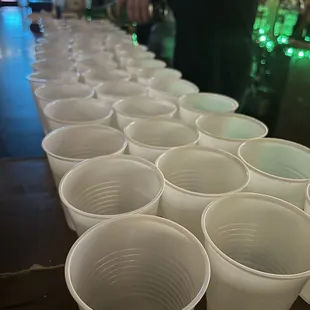 rows of plastic cups lined up on a bar