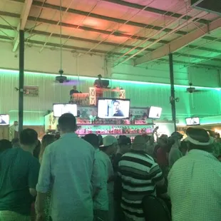 a crowd of people watching televisions