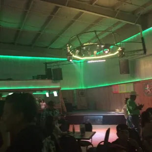 a group of people in a room with green lights