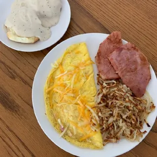 an omelet, hash browns, ham and gravy