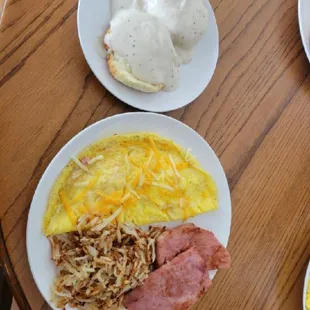a breakfast of eggs, ham, hash browns and gravy