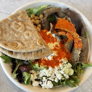 a bowl of food with pita bread