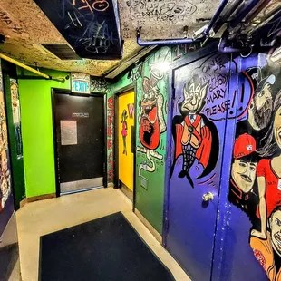 a bathroom with graffiti on the walls