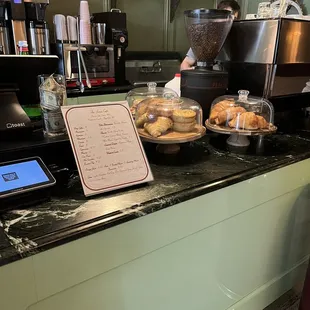 a counter with pastries and a menu