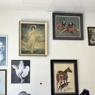 a wall full of paintings