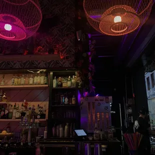 a dimly lit bar with purple lighting