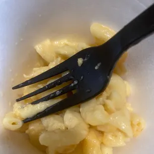 ows a fork in a bowl of macaroni and cheese