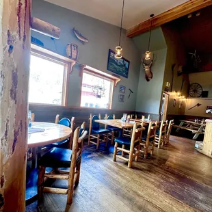 a dining room with wooden tables and chairs