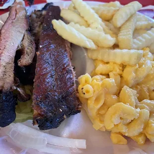 a plate of meat, macaroni, and cheese