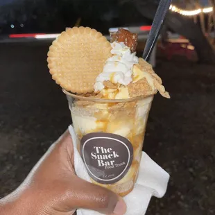 a hand holding an ice cream sundae