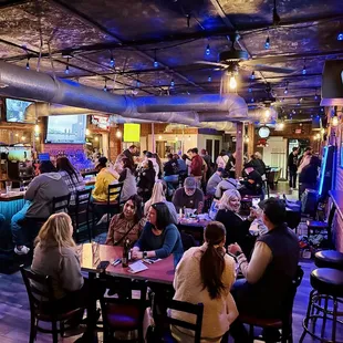 a large group of people sitting at a bar