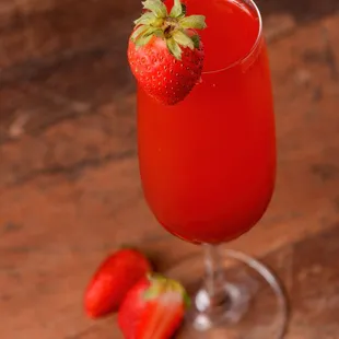 a glass of red wine with strawberries