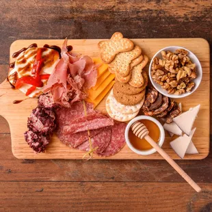 a platter of meat, cheese, crackers, and nuts