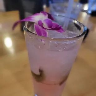 a pink drink with a purple flower