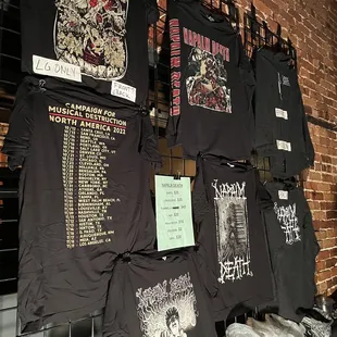 a number of t - shirts hanging on a wall