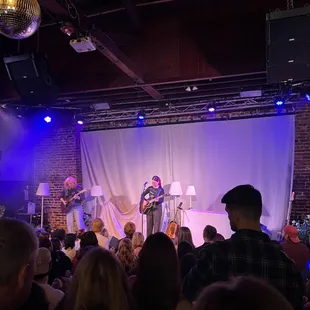 a group of people watching a band perform on stage