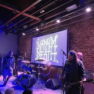 a band performing in front of a large screen