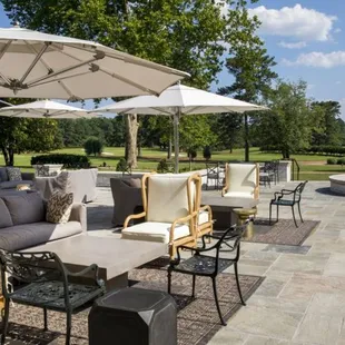 a patio with tables, chairs, and umbrellas