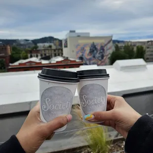 two people holding coffee cups